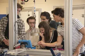 Group of students around experiment involving weights