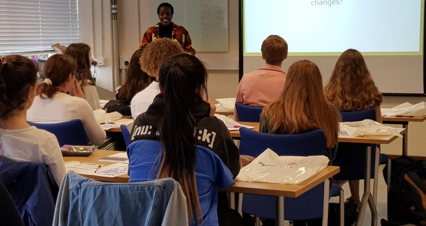 DPhil student Naomi Mburu giving a presentation to a classroom of young female students