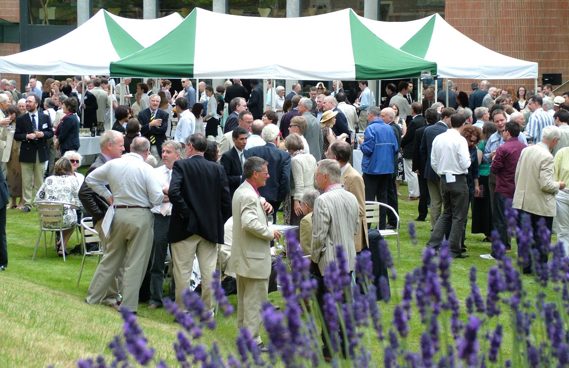 Centenary event, guests in college garden with marquee