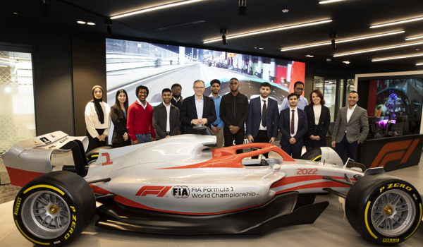 Undergraduates stood behind Formula 1 racing car