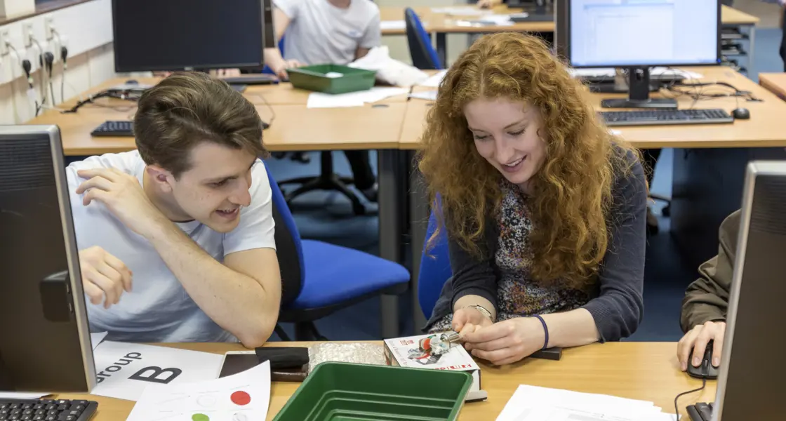 Students at computer desk working on project together