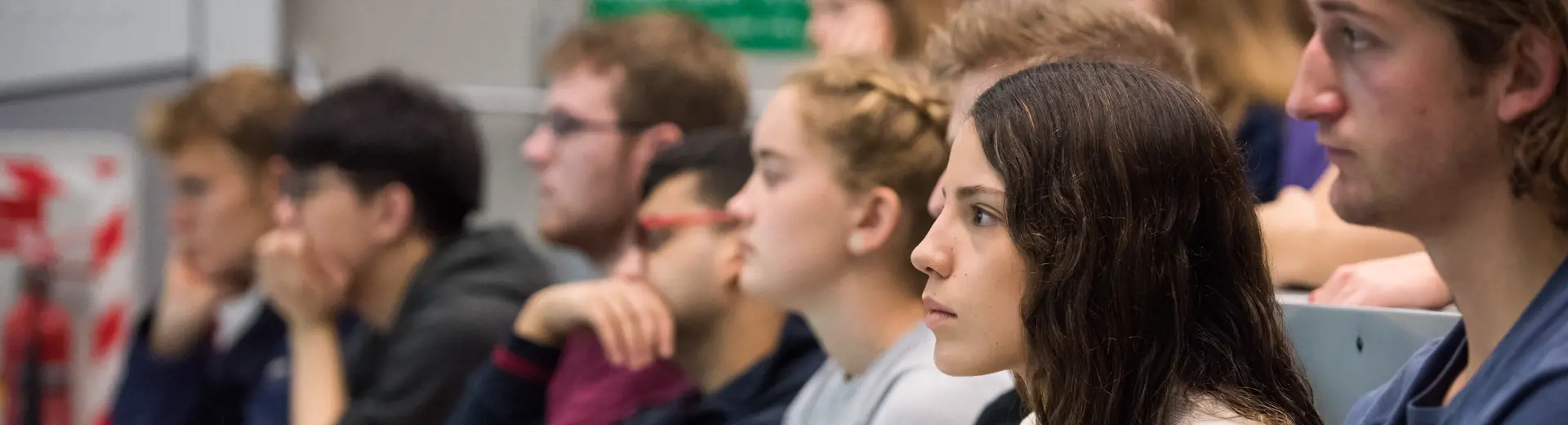 Close up of row of young students listening to lecture