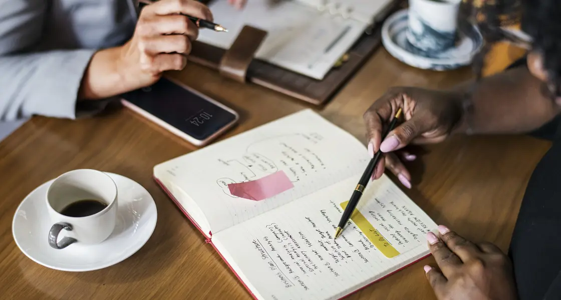People working in coffee shop discussing notes