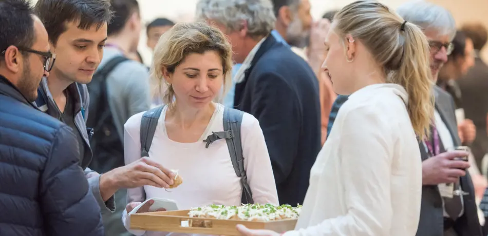 Alumni being served food at an event in the Maths Institute