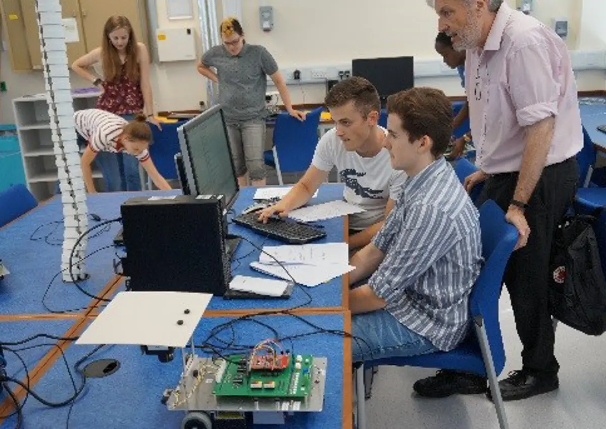 Students sat at a computer chatting to an academic