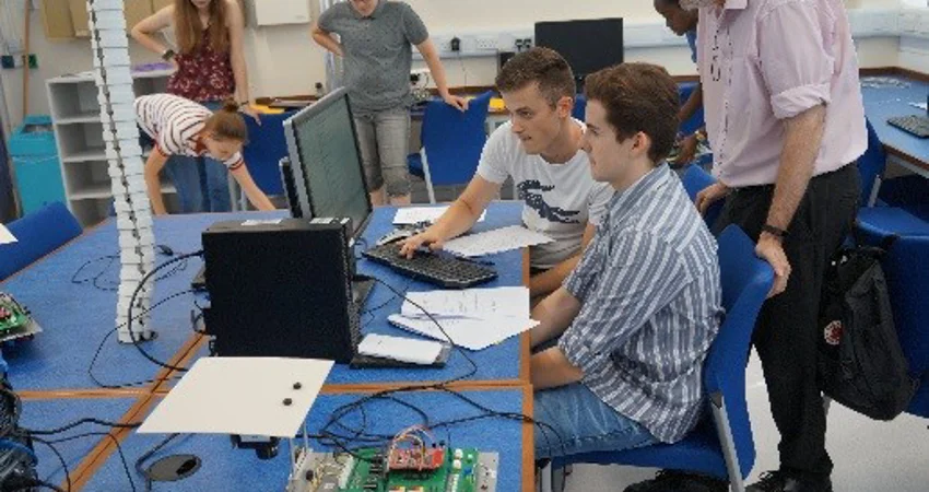 Students sat at a computer chatting to an academic