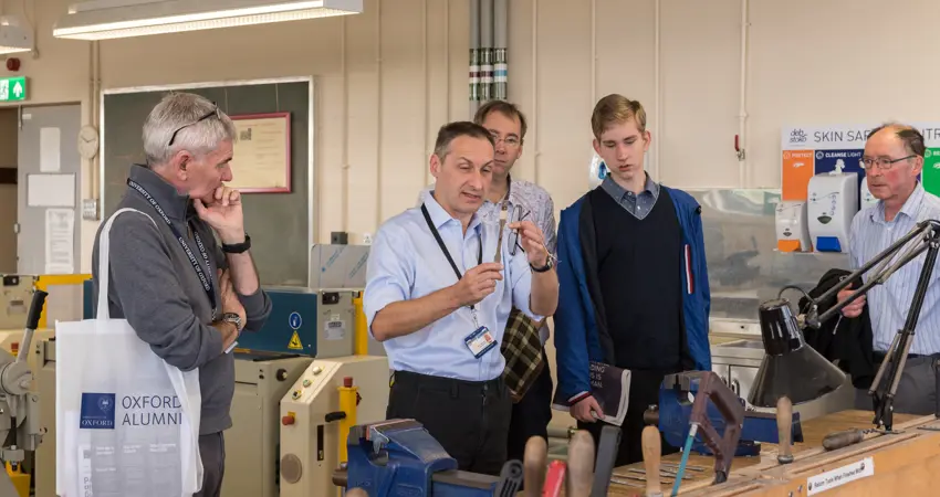 Man demonstrating in lab to group of men