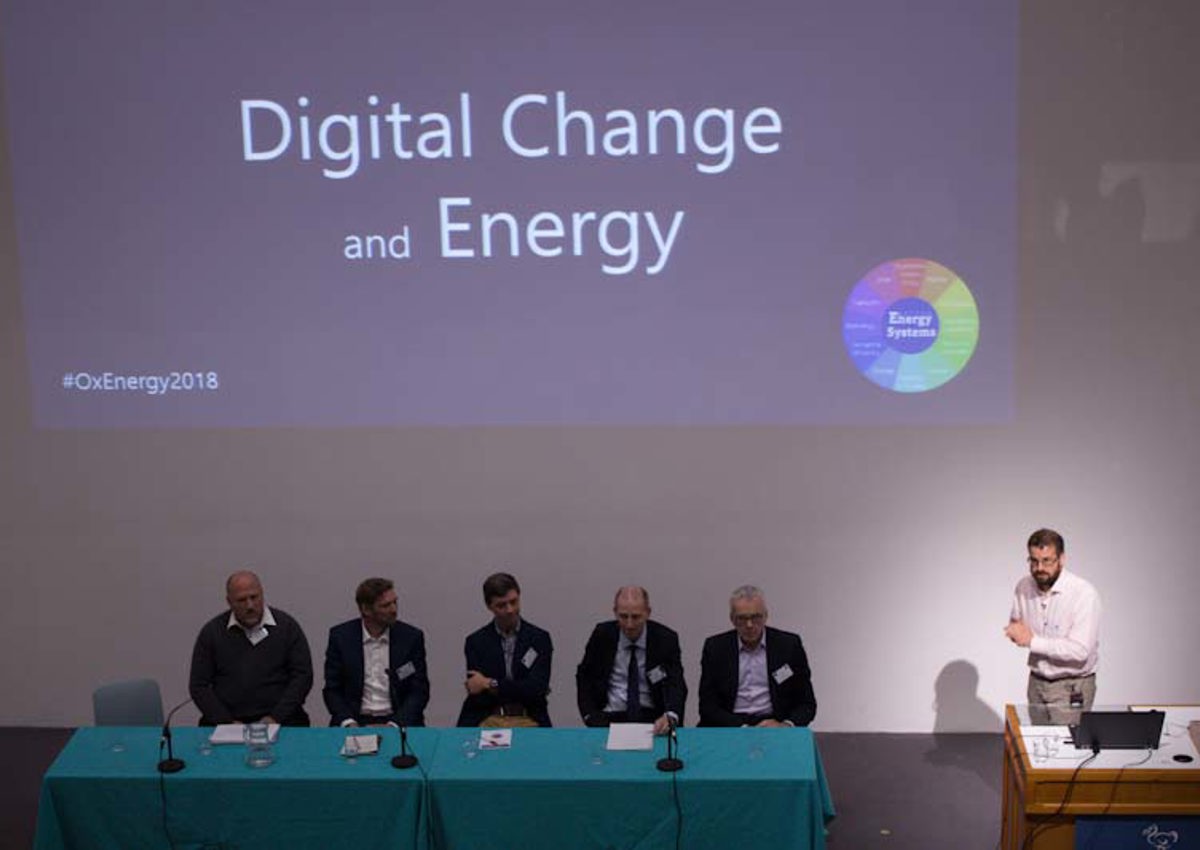 Professor David Wallom presenting at the Oxford Energy Day in 2018, with a panel of experts on stage