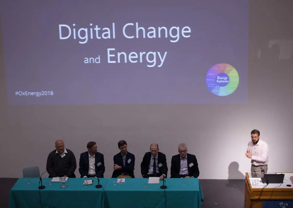 Professor David Wallom presenting at the Oxford Energy Day in 2018, with a panel of experts on stage