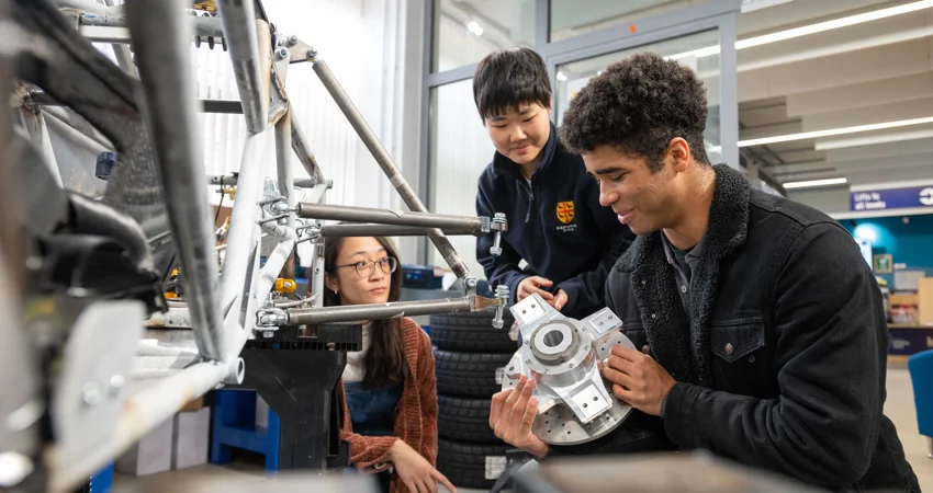 Students looking at parts of the Formula Student car (photo credits John Cairns)