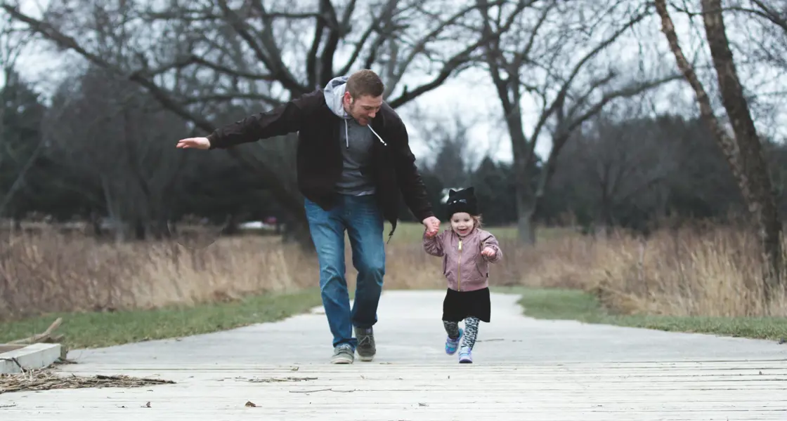 Father and young child out for a walk in autumn