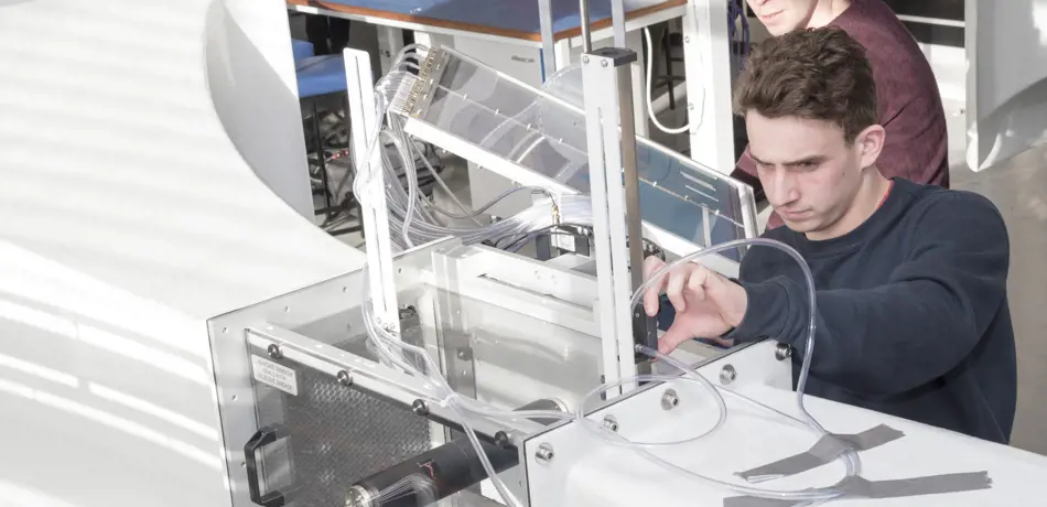 Two students working on wind tunnel machine