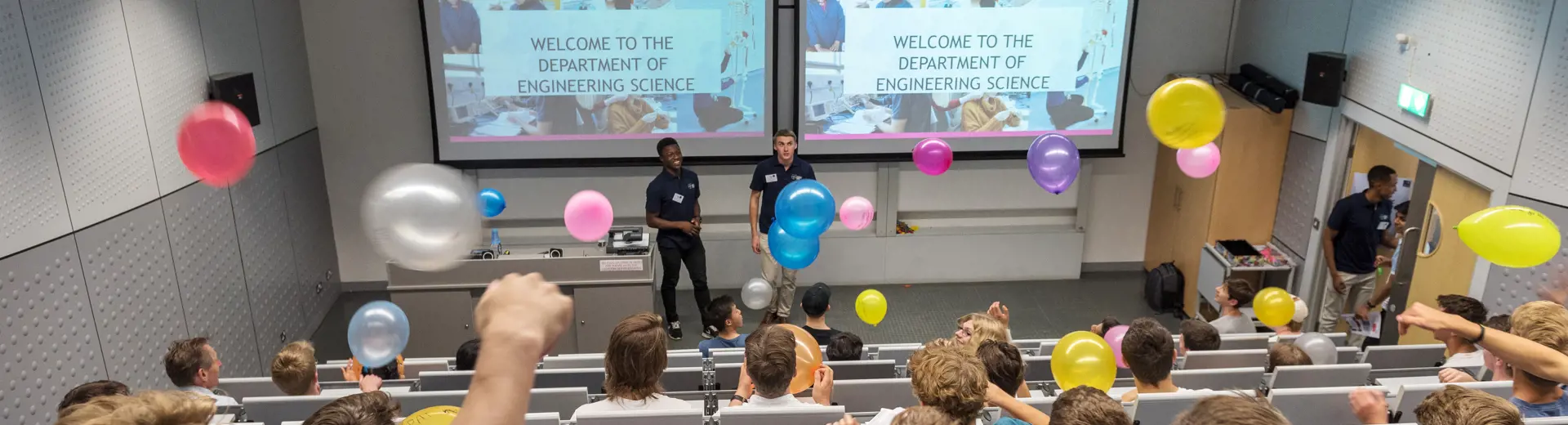 Welcome to the department lecture, with audience throwing colorful balloons