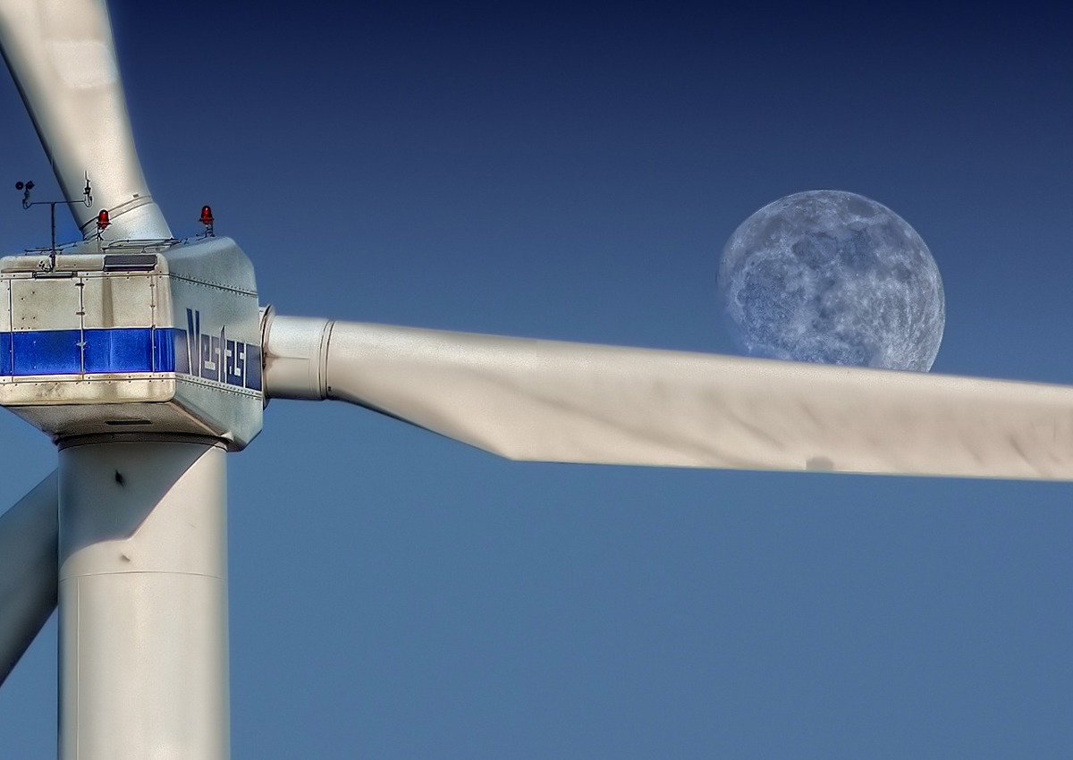A wind turbine with the moon in the background