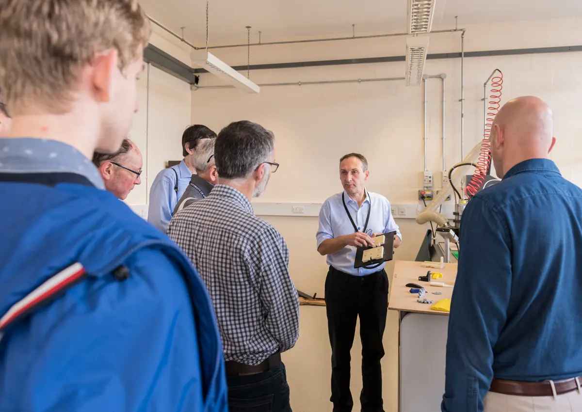 Man talking to a group of people in a workshop