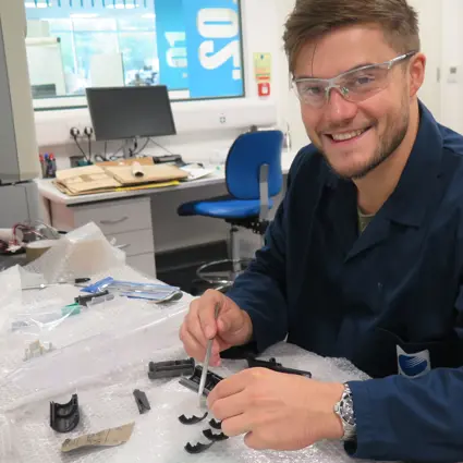 Man smiling wearing safety glasses and lab coat