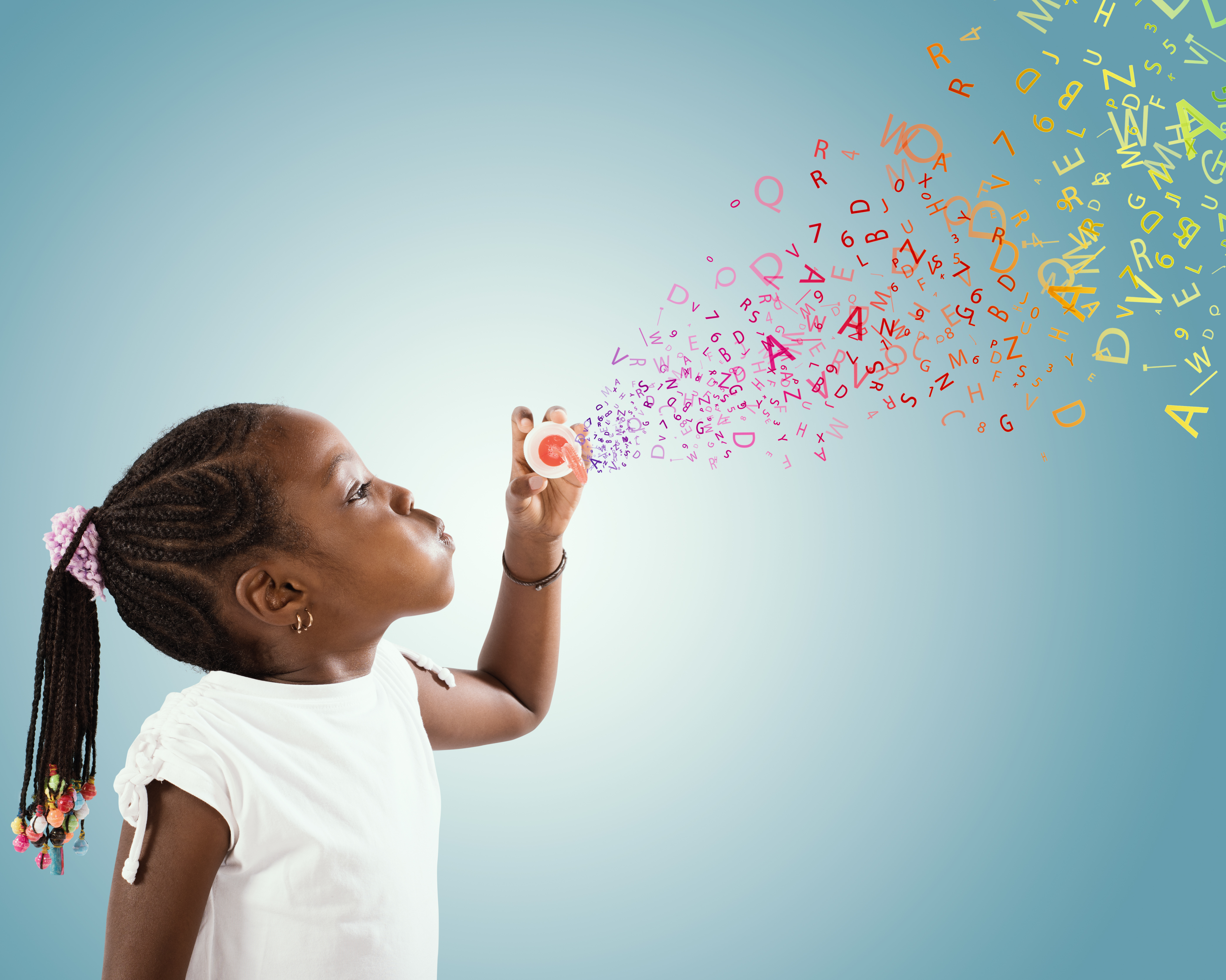 A child blowing bubbles, but instead of bubbles it is colourful letters of the alphabet