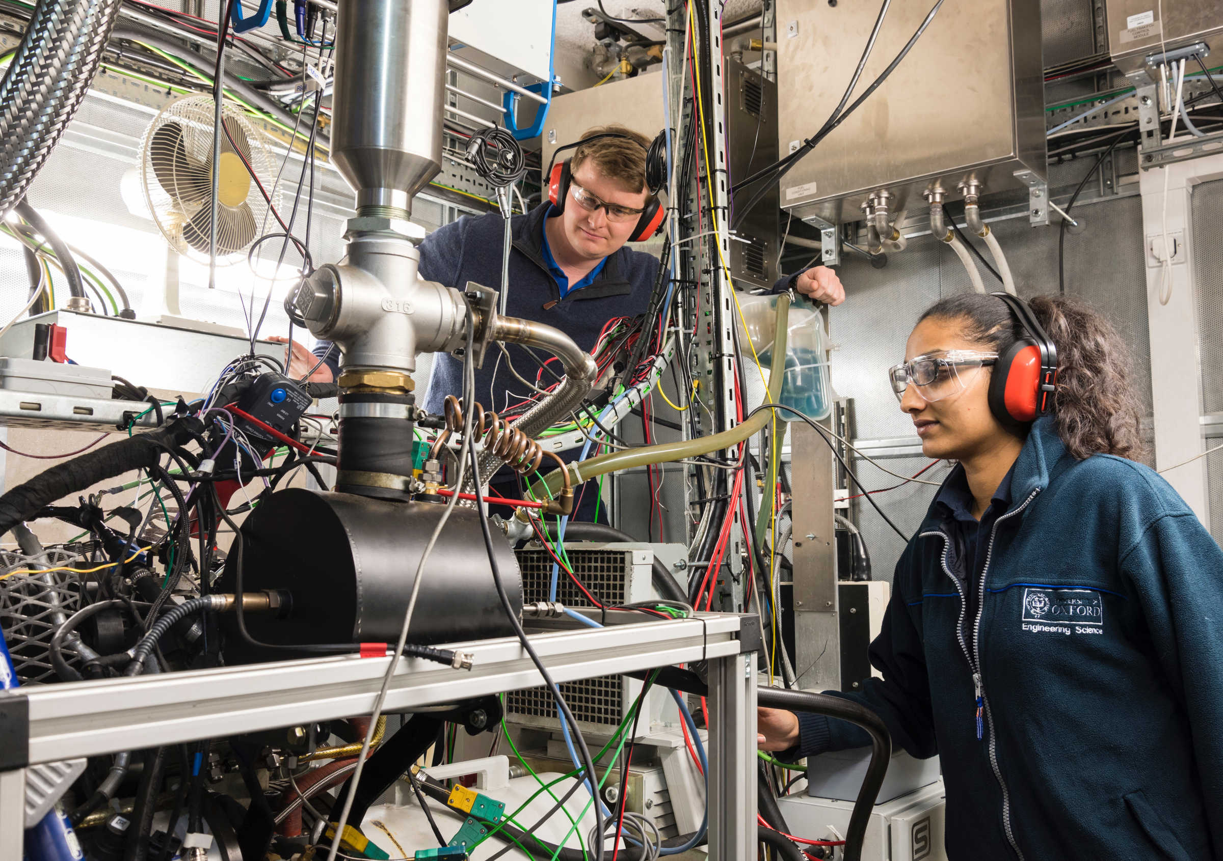 Students in a lab wearing protective hearing and safety glasses