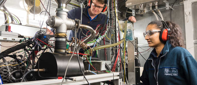Students in a lab wearing protective hearing and safety glasses