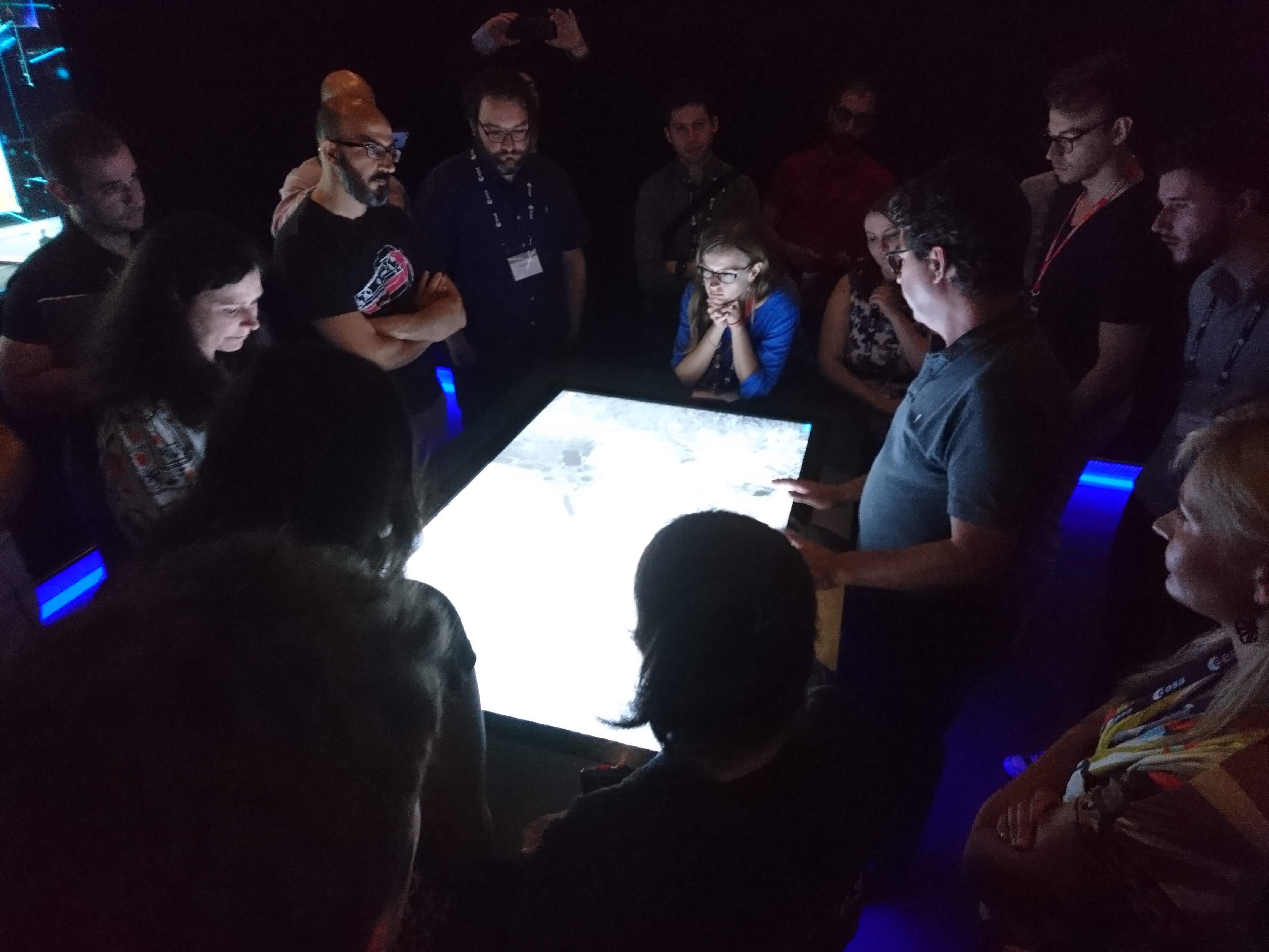 Frontier Development Lab team members looking at images on a lightbox