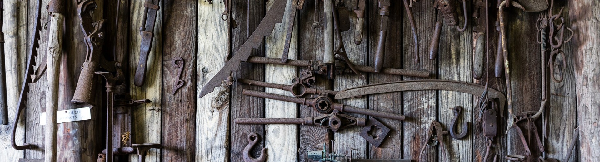 Rusty tools on bench and wall
