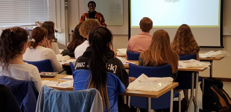 DPhil student Naomi Mburu giving a presentation to a classroom of young female students