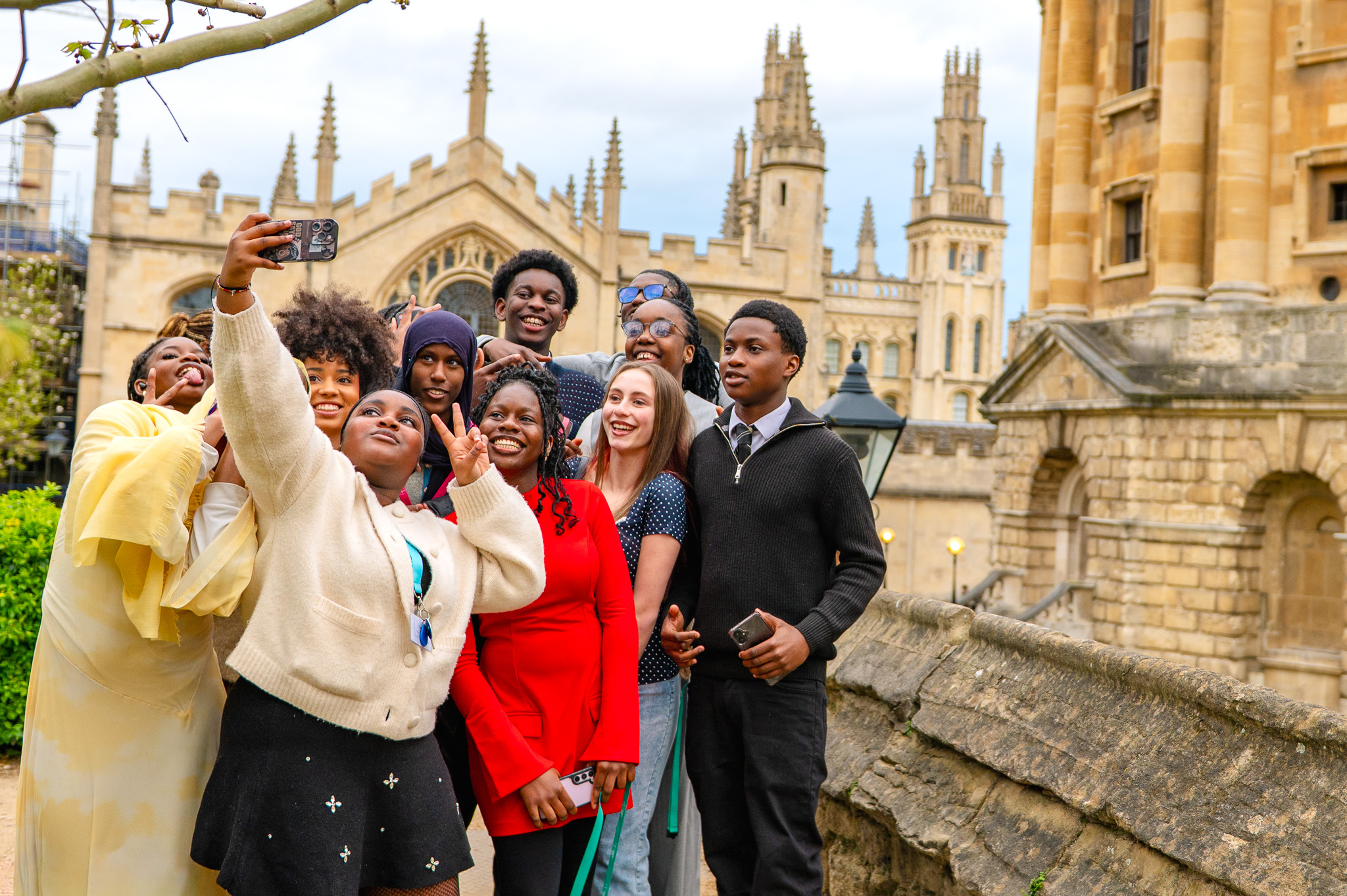 Students gather together taking a selfie with Oxford college buildings in the background during the residential programme.