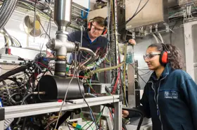 Students in a lab wearing protective hearing and safety glasses
