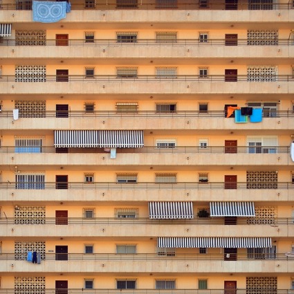 Several balconies of an apartment block in a hot country