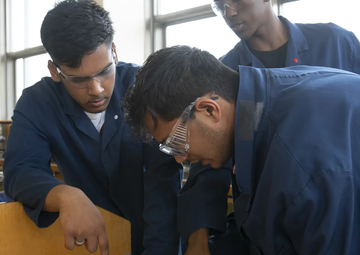 Group of students working on problem together in safety gear