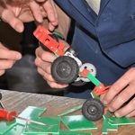 Close up of student hands working with small wheelie car