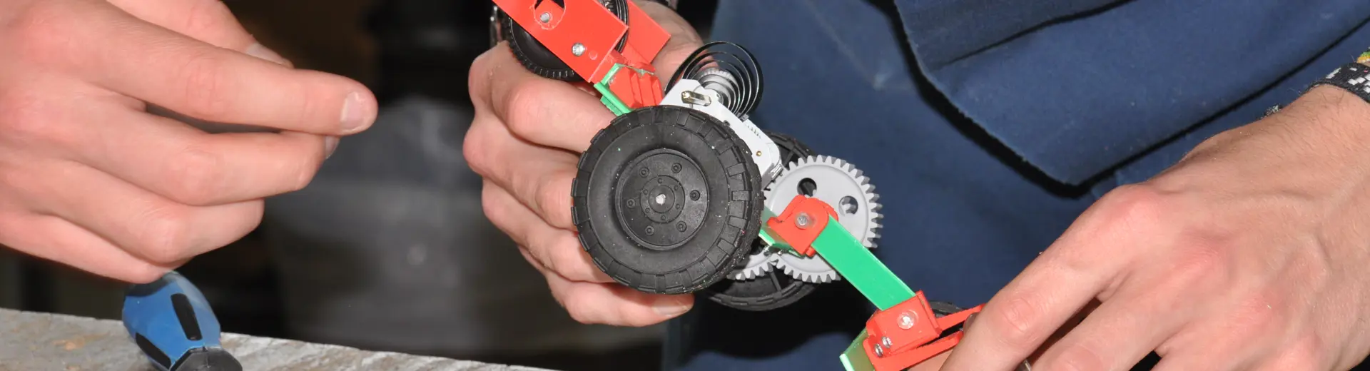 Close up of student hands working with small wheelie car
