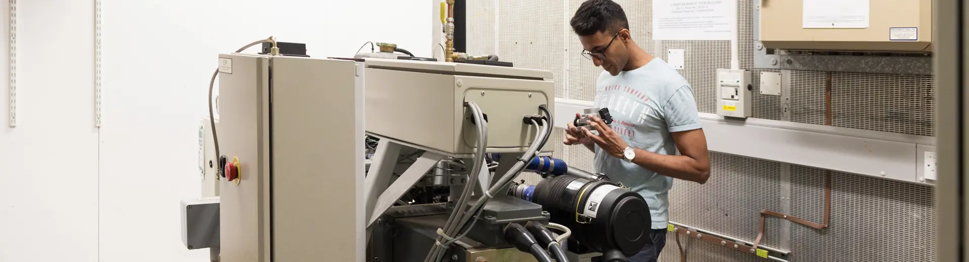 Student working on a machine at the centre of a large room