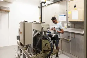 Student working on a machine at the centre of a large room