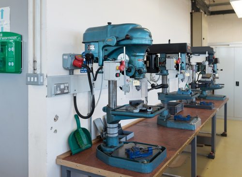Row of several large drilling machines in a lab