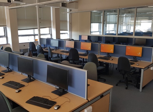 Several long desks with many desktop computer stations