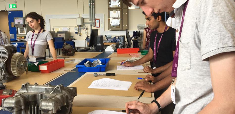 Students at workbenches writing on problem sheets