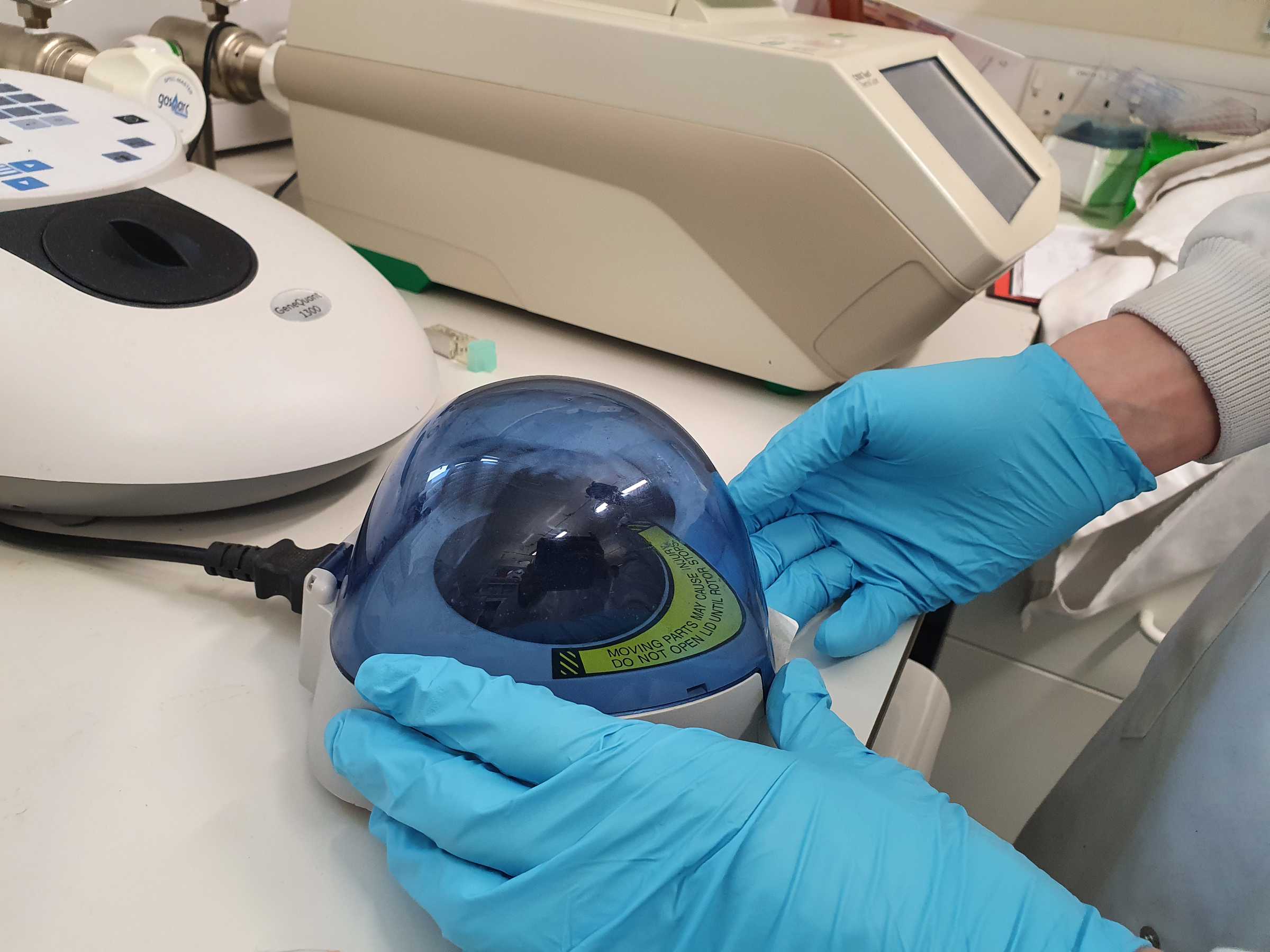 Researcher using a device to check samples for COVID-19 RNA and RNA fragments