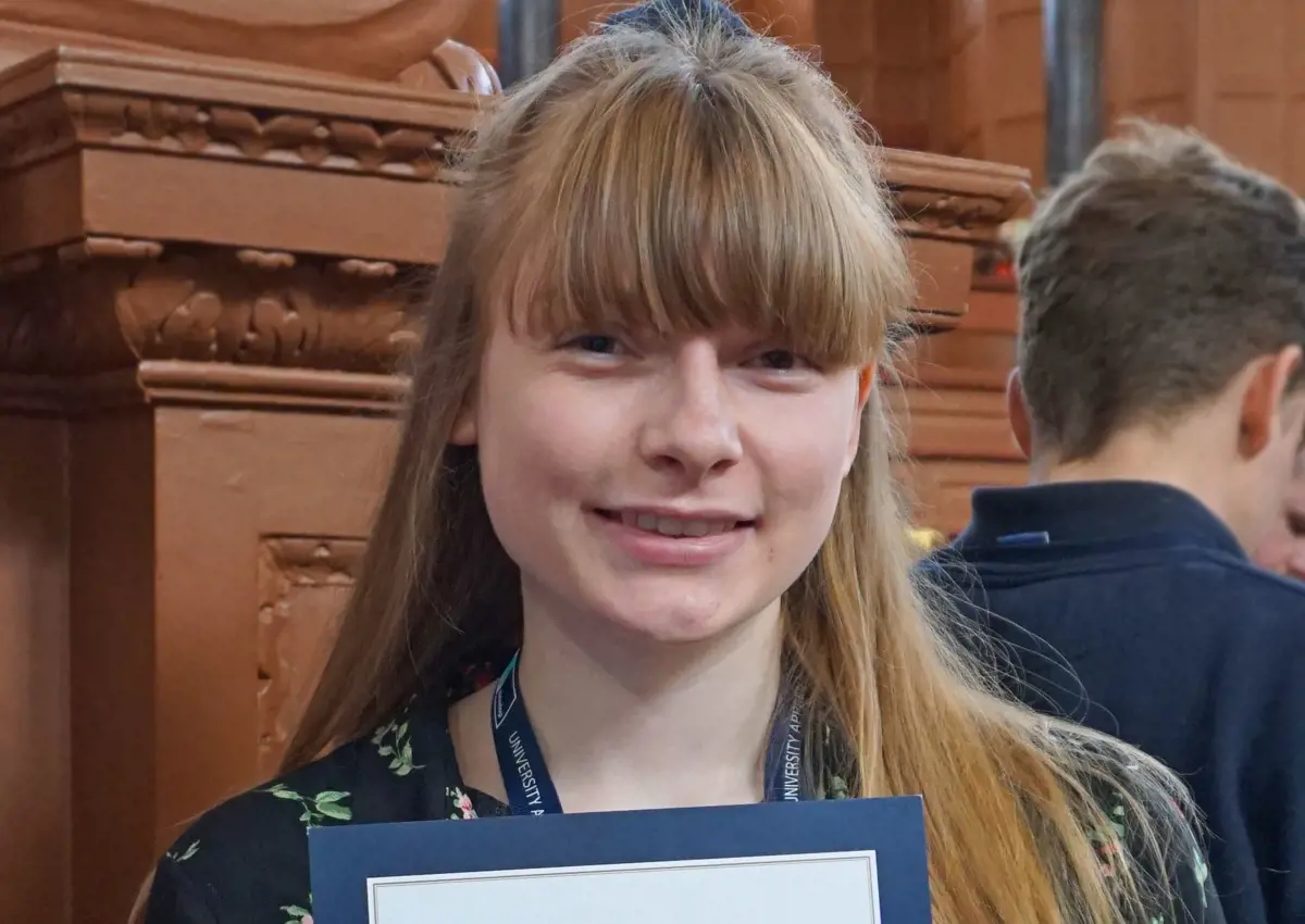 Freya Cook, Apprentice Finance Assistant, holds up her certificate as finalist in the 1st Year category