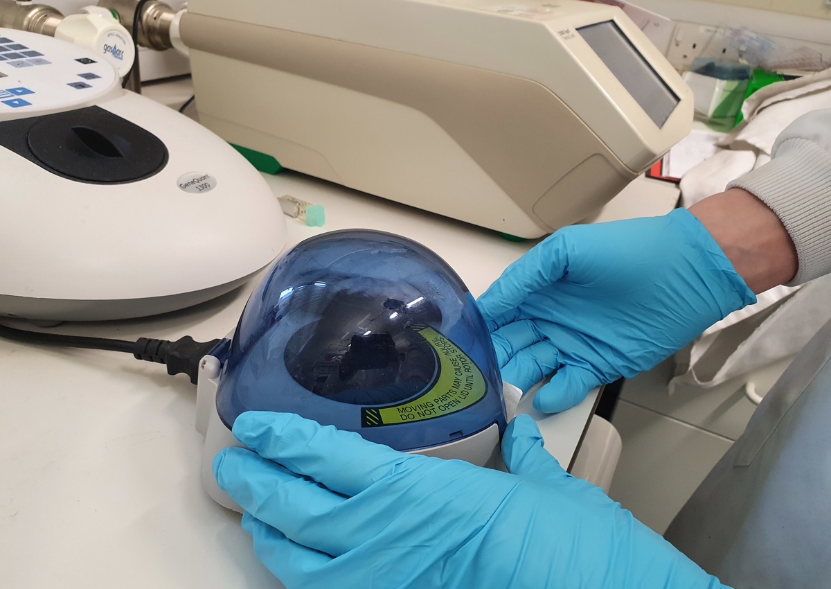 Researcher using a device to check samples for COVID-19 RNA and RNA fragments
