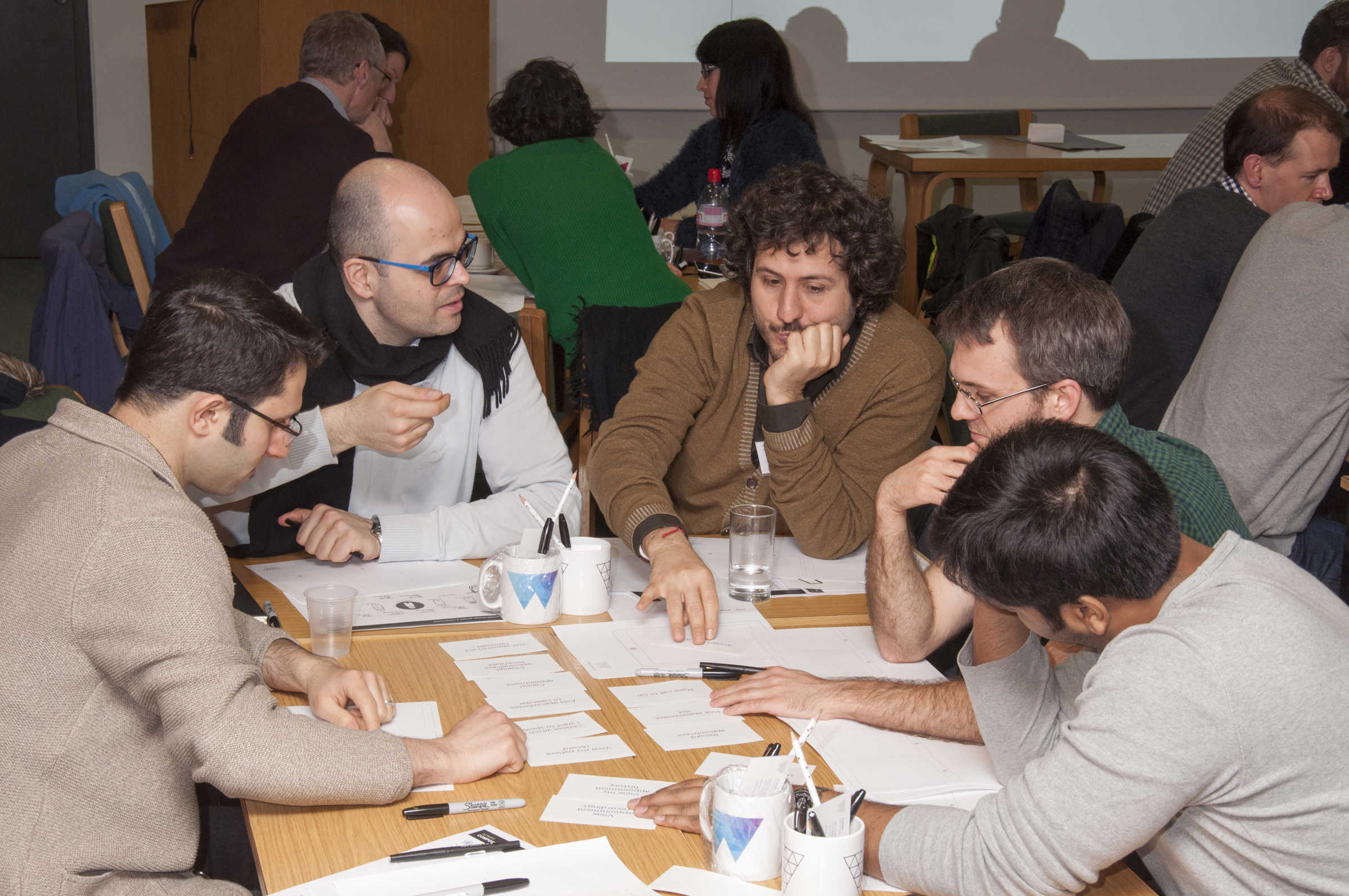 Tables of groups of academics discussing and working together