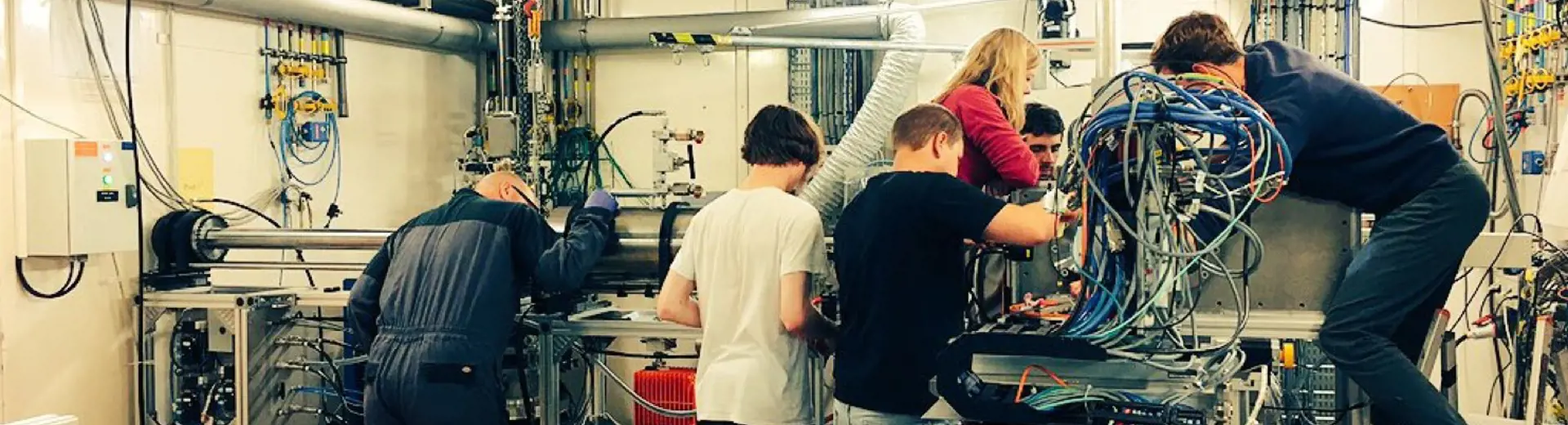 A photo of people working around a large machine in the lab