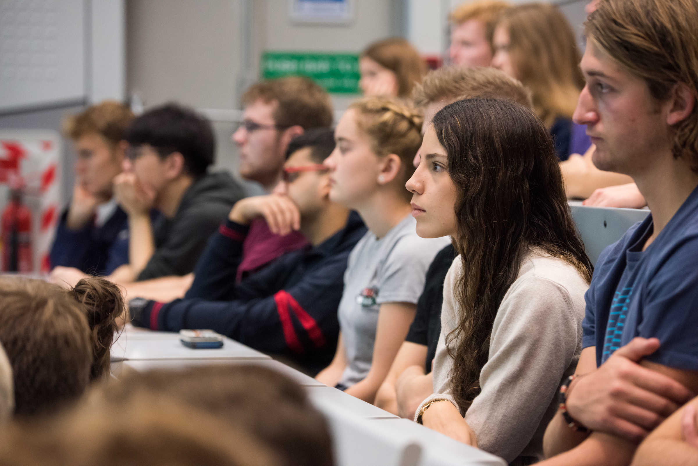 Close up of row of young students listening to lecture