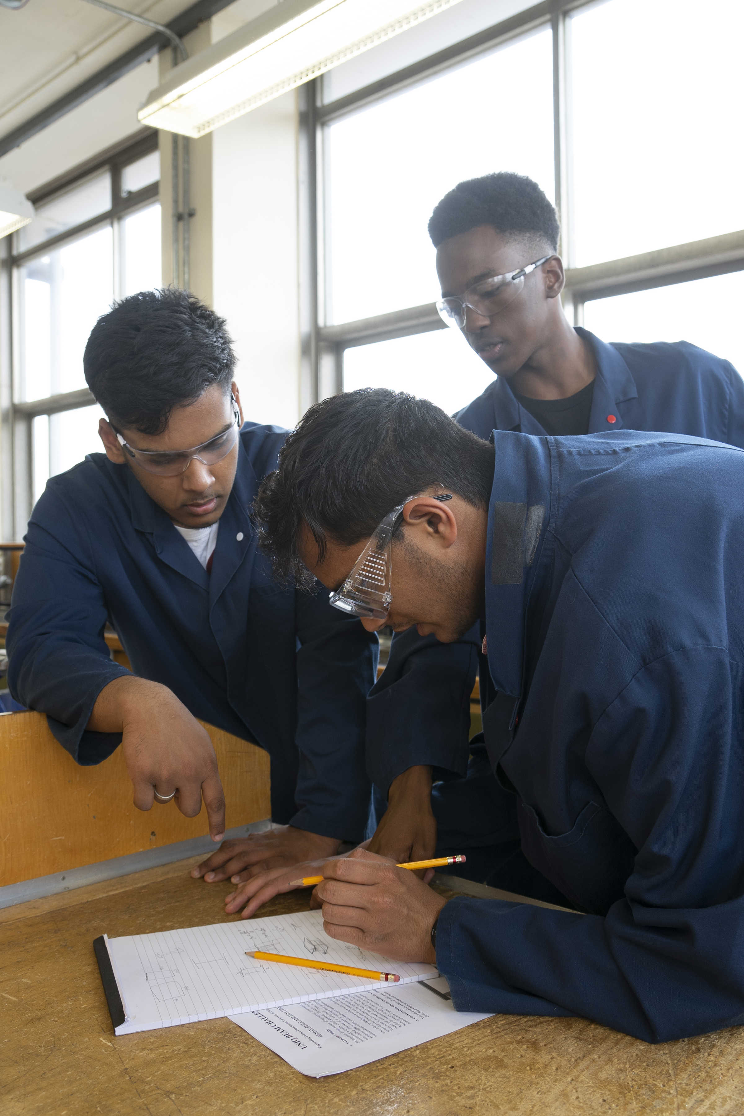 Group of students working on problem together in safety gear
