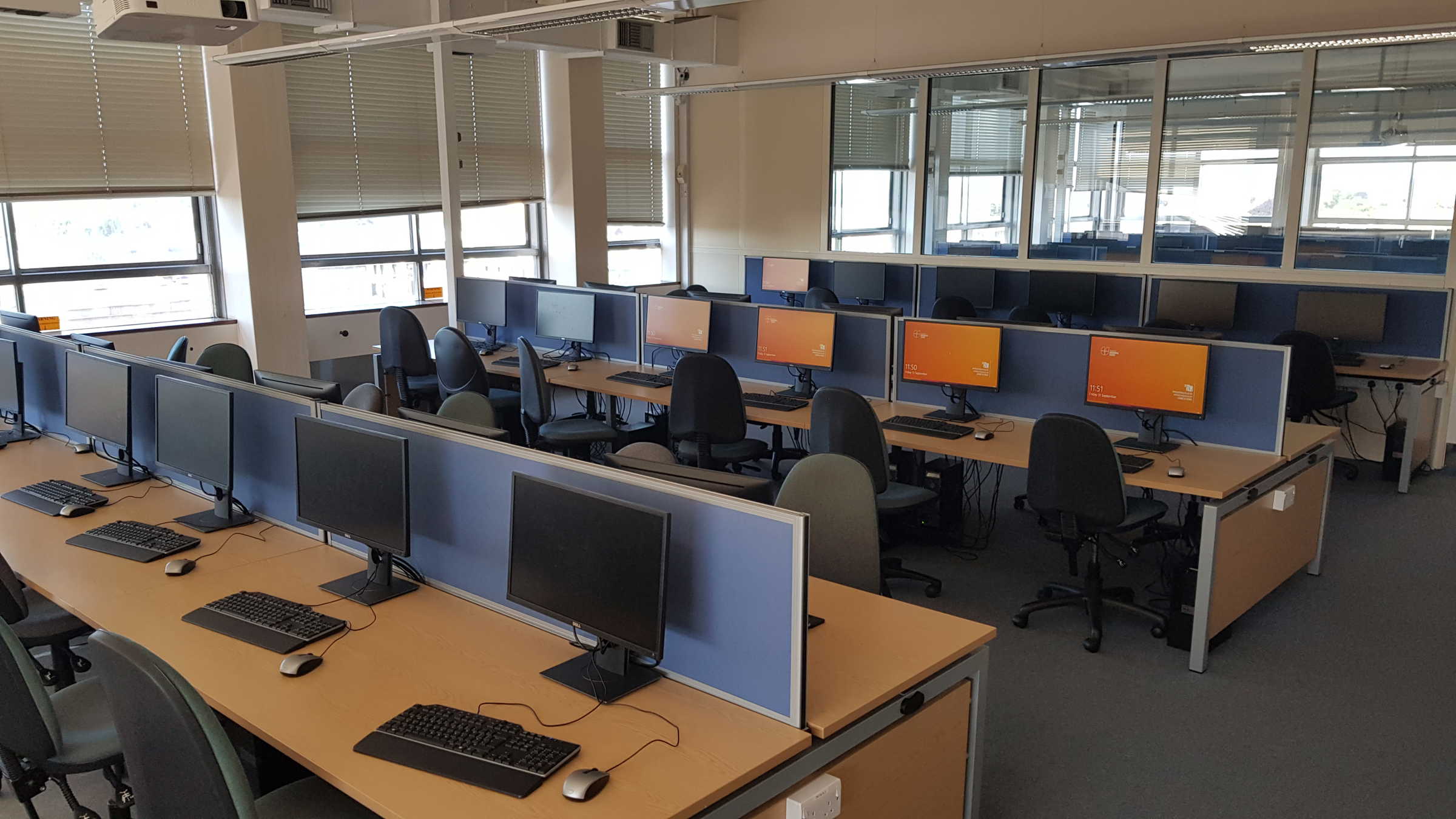 Several long desks with many desktop computer stations