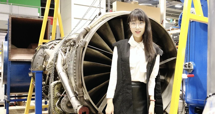 Muting Hao: a photo of Muting, an East Asian woman, standing by a turbine.