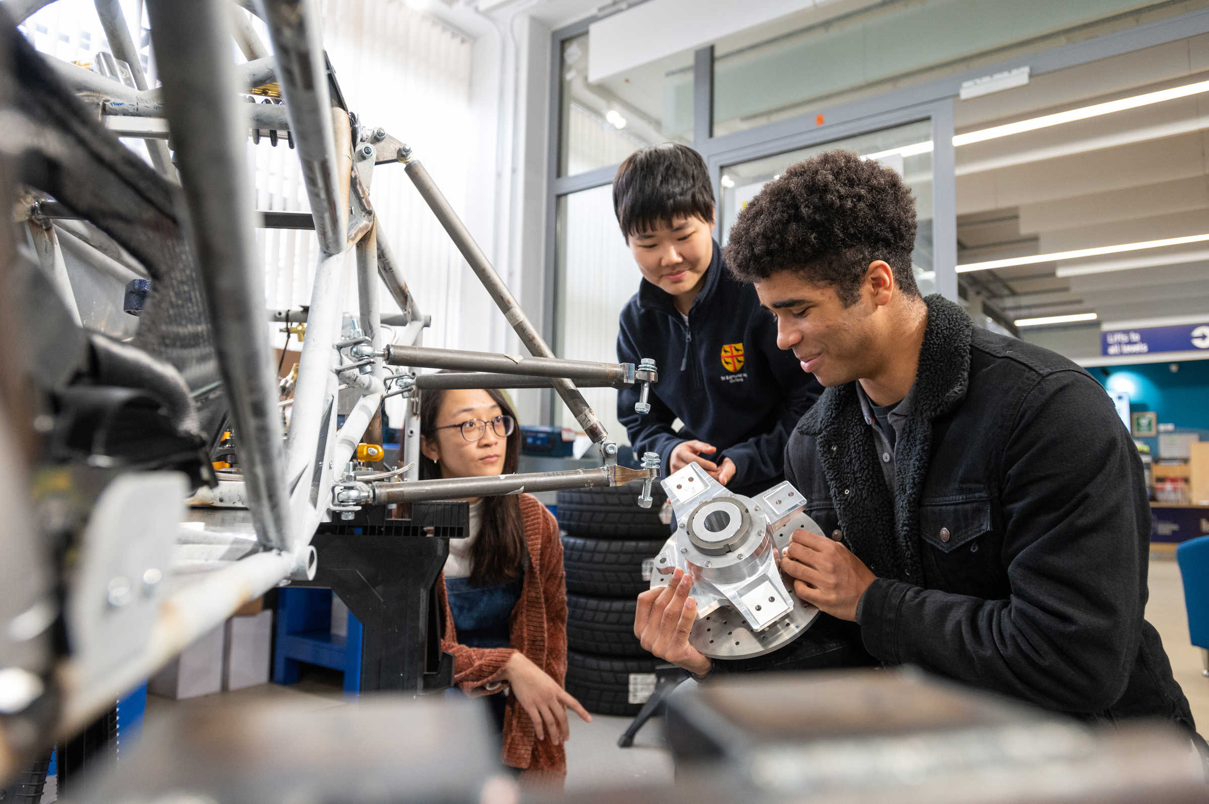 Students looking at parts of the Formula Student car (photo credits John Cairns)