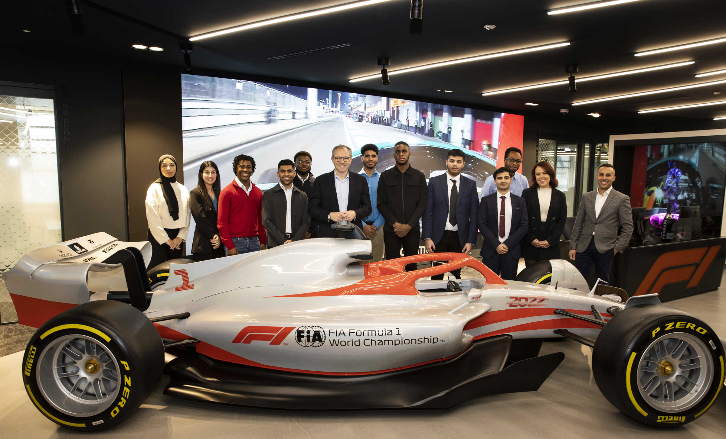 Undergraduates stood behind Formula 1 racing car