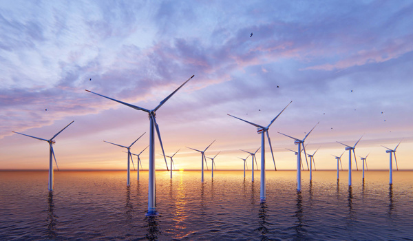 A wide-angle view of an offshore wind farm at sunset, with numerous wind turbines standing in calm ocean waters. The sky is painted with soft hues of purple, pink, and orange, and birds can be seen flying in the distance. The sun is low on the horizon, creating a serene and sustainable energy scene.