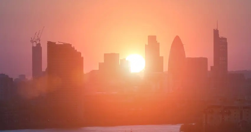 Sun rises over London buildings along the Thames